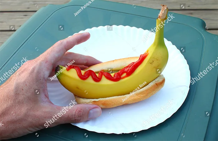 Hot dog with unpeeled banana instead of sausage and ketchup on top