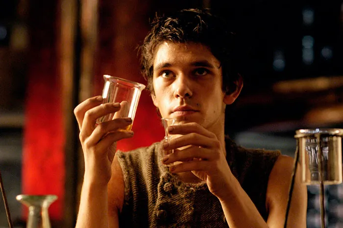 Young man examining glass containers in a dimly lit scene from Perfume movie, linked to fun facts about movies.