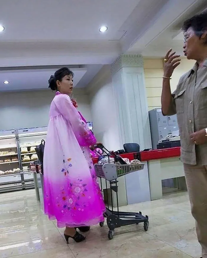 A woman wearing pink dress shopping 