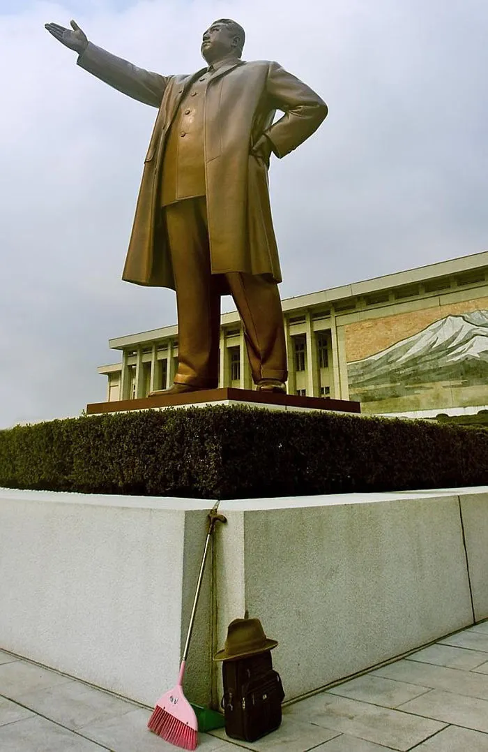 A broom standing in front of the Kim's statue 