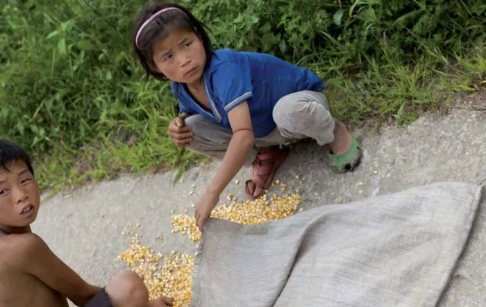 Two kids collecting grains 