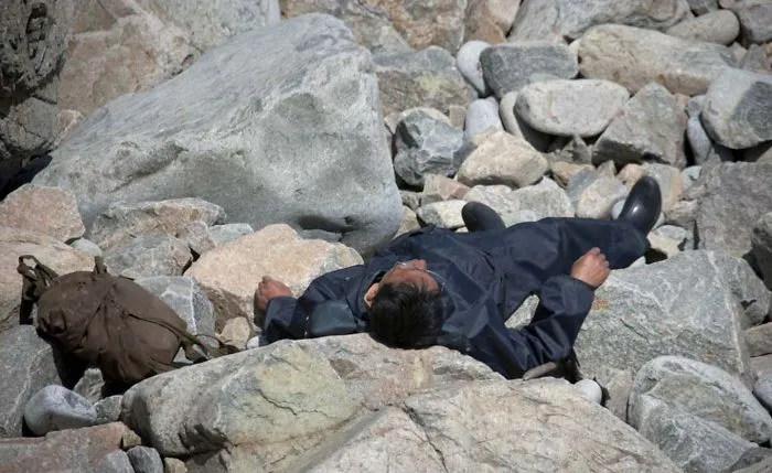 A man resting on the rocks by the sea
