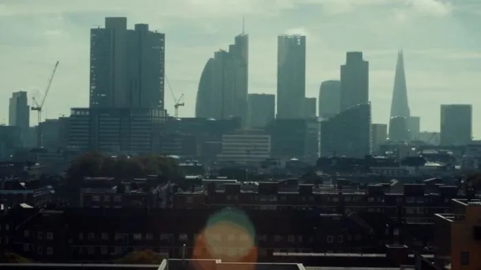 City skyline with modern skyscrapers and cranes under a cloudy sky, showcasing urban development in a thriving metropolis.