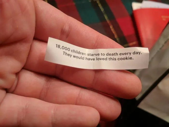 Fortune cookie with a sassy message held in hand, against a colorful background.