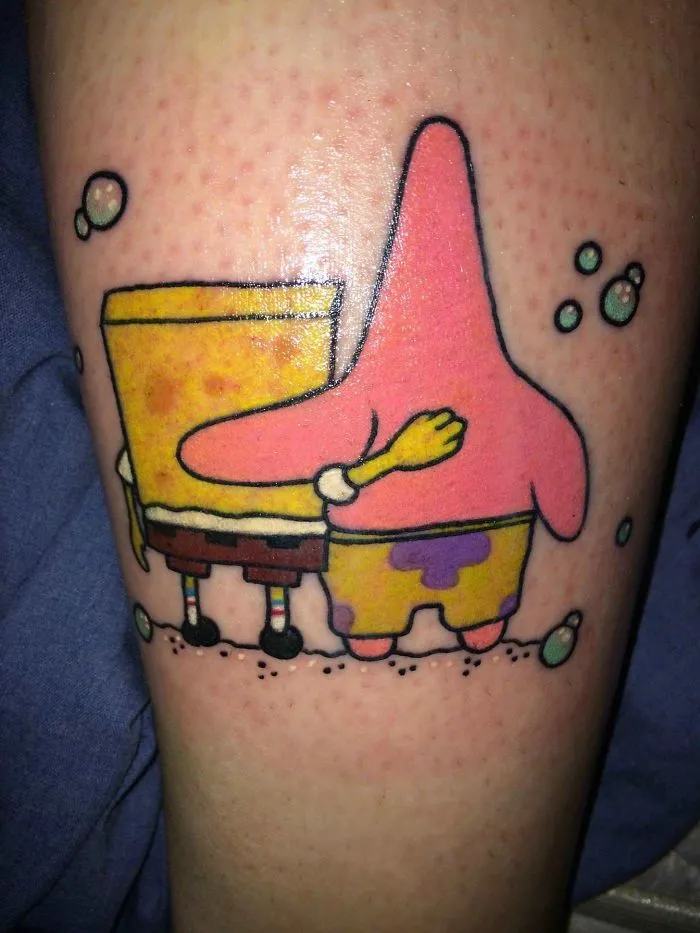 Tattoo of two cartoon characters embracing, symbolizing friendship and meaningful stories behind tattoos.