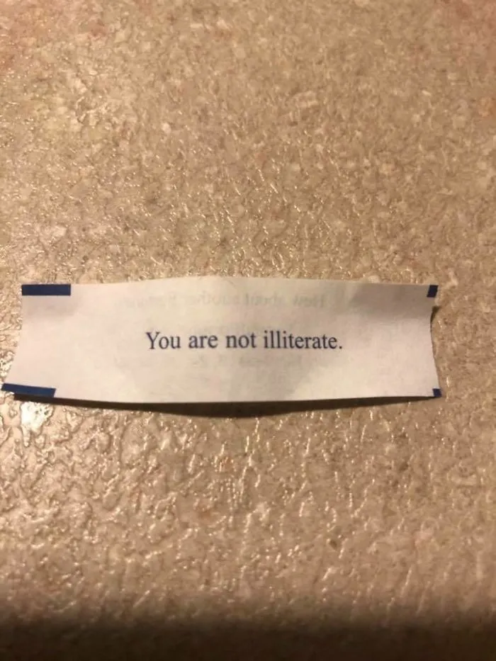 Sassy fortune cookie saying on a slip reads, "You are not illiterate."