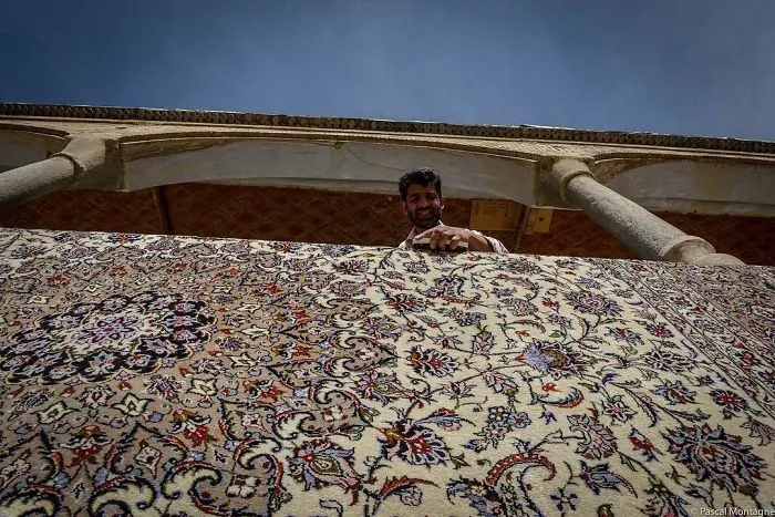Un hombre lava una alfombra en un bazar de Isfahan