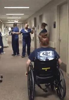 A Nurse Bends Down And Gets Ready To Hug Her Former Patient, Who Was Paralyzed From The Waist Down