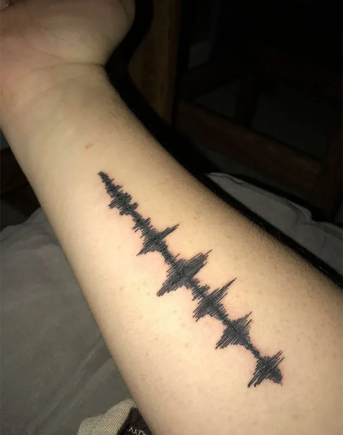A waveform tattoo on a forearm symbolizing a powerful story and real meaning.