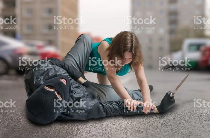 Mujer inmovilizando a un ladrón que ha olvidado que tiene 2 manos