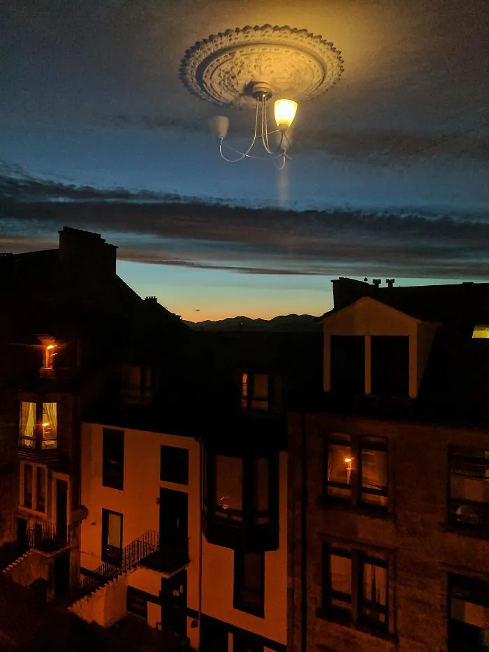 El reflejo de la lámpara en la ventana, parece que está flotando en el cielo