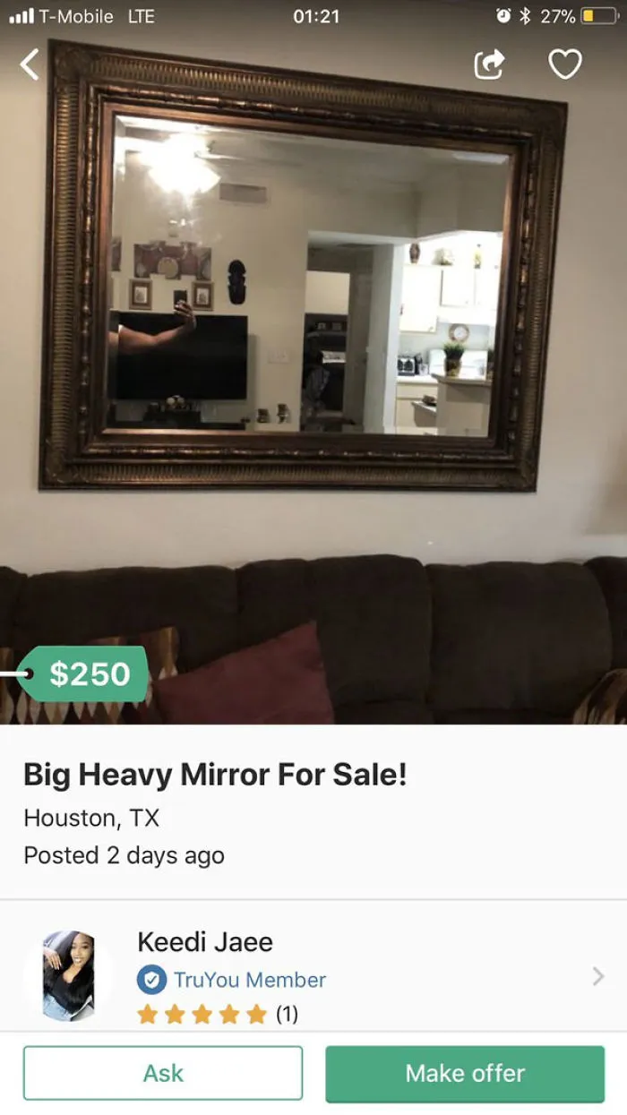 Large ornate mirror for sale, reflecting a living room and kitchen scene in a cozy home setting.
