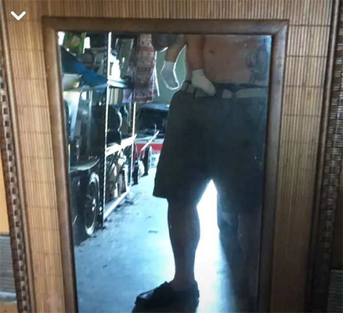 Person reflected in a mirror with a baby, showcasing the humorous side of selling mirrors online.