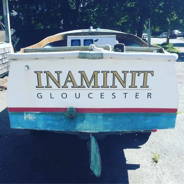 Funny named white boat parked in a parking lot 