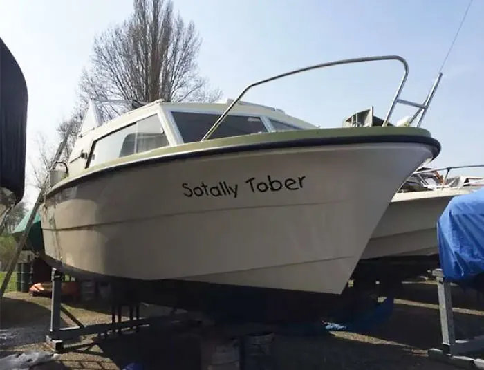 Funny named white boat on the ground 