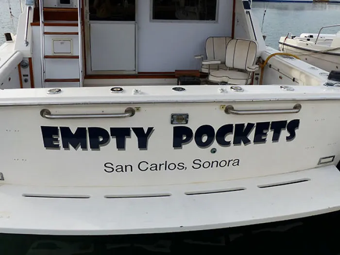 Funny named white boat docked 