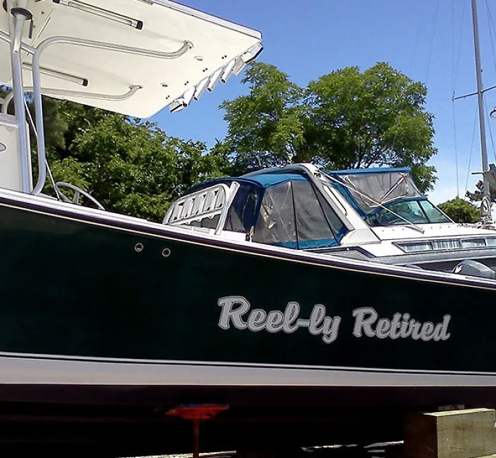 Funny named white and black colored boat docked 