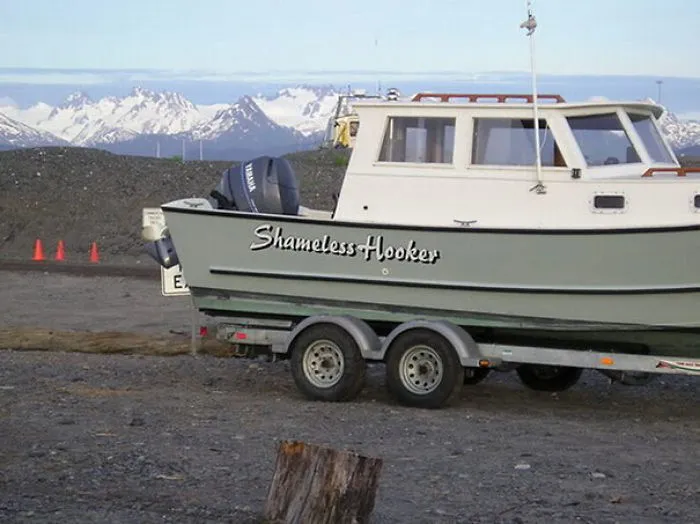 Funny named boat being pulled in a trailer
