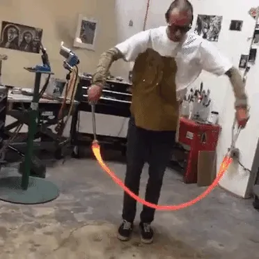 Vidriero saltando a la comba con vidrio fundido caliente