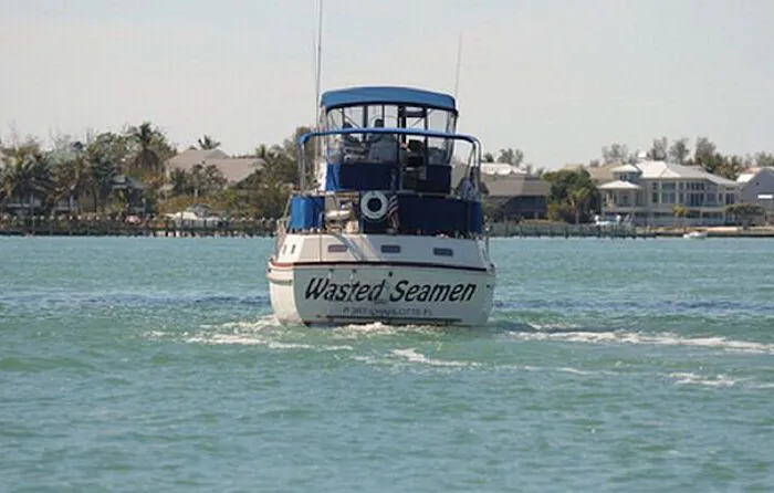 Funny named whit and blue boat swimming 