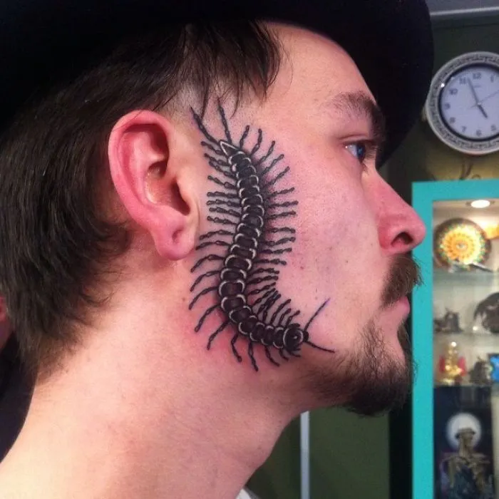 Centipede tattoo on a man's face, showcasing an example of bad tattoo fails.