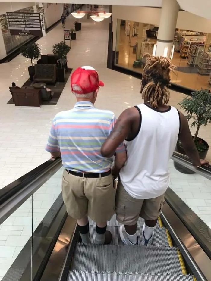 Joven ayudando a un anciano en las escaleras