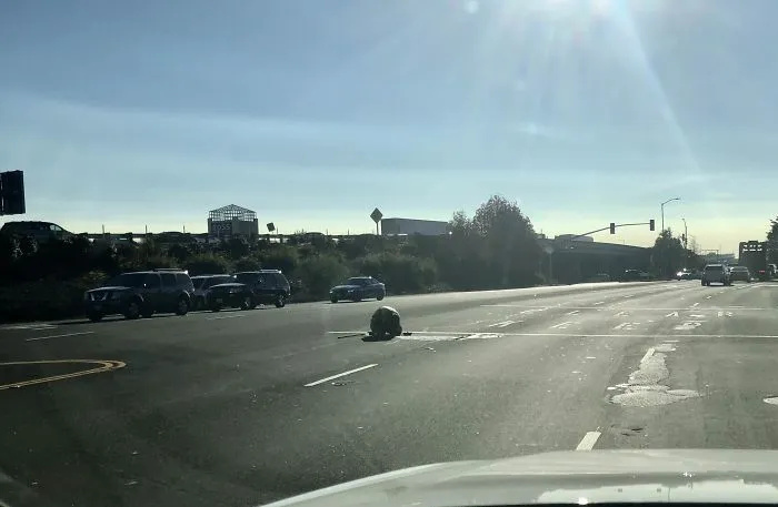 Trabajador en una alcantarilla, en medio de una carretera de 4 carriles, sin conos, ni vallas, solo un chaleco naranja