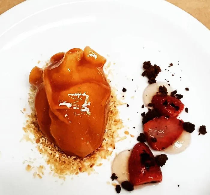 Galleta rellena de ganache, fresas chamuscadas, gel de rosa quemada y coco