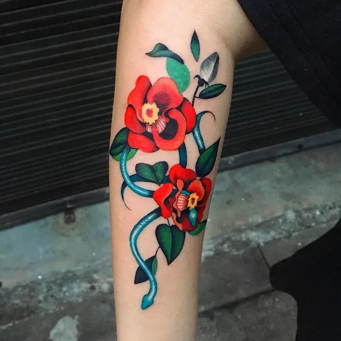 Vibrant snake and flower tattoo on arm by Korean artist, showcasing unique style.