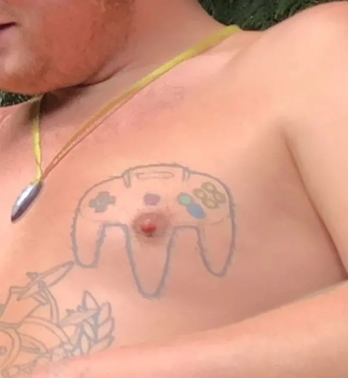 Chest tattoo fail featuring a game controller design around a nipple.
