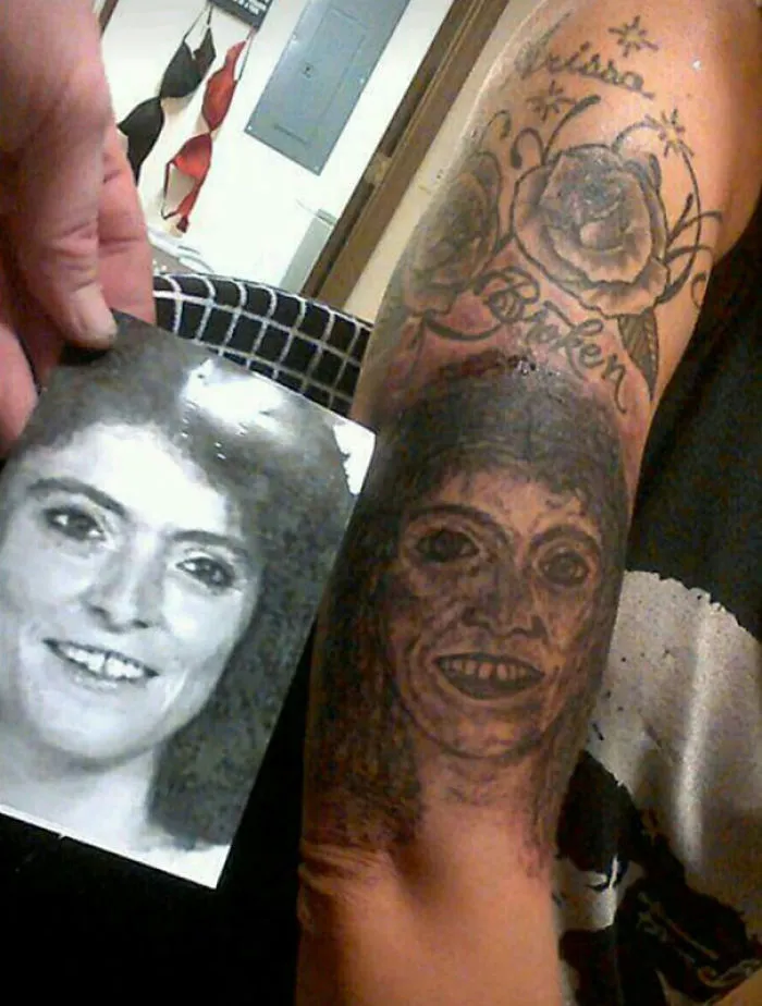 Bad tattoo fail with a portrait that poorly resembles the original photo held next to it.
