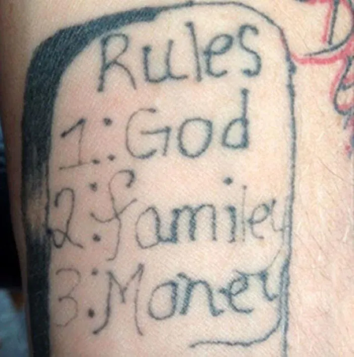 Bad tattoo fail with misspelled 'family' in a list of priorities on skin.