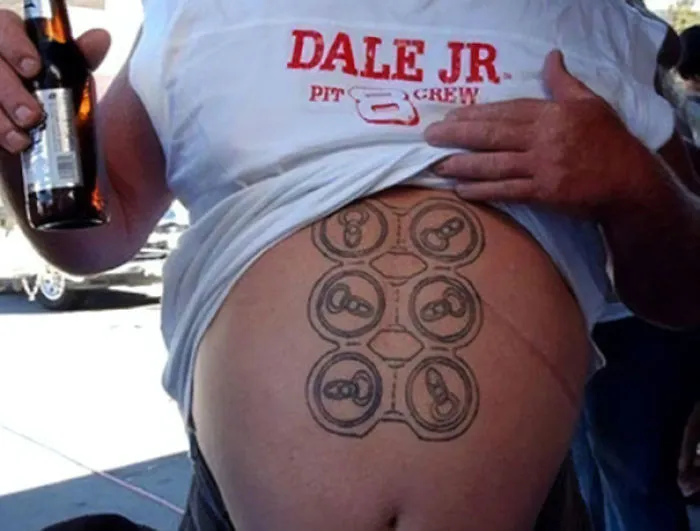 Man with a tattoo of soda can tops on his stomach, holding a beer, wearing a "Dale Jr. Pit Crew" shirt. Bad tattoo fail.