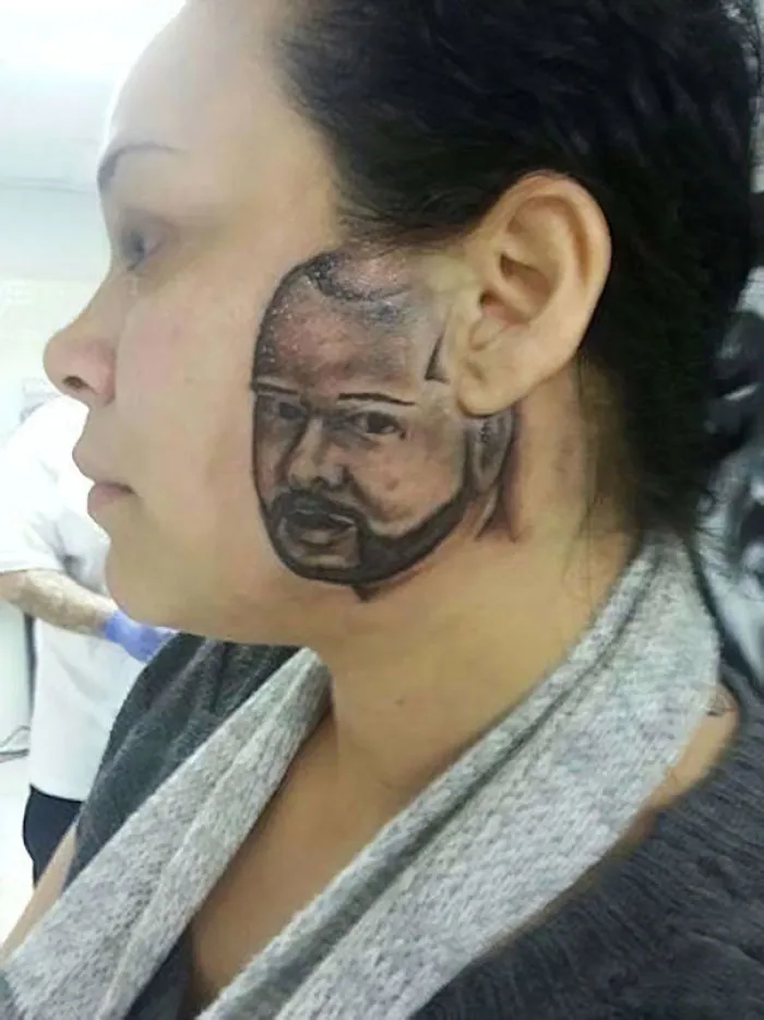Face tattoo fail on woman's cheek, unusual concept and execution make it a funny and cringeworthy moment.
