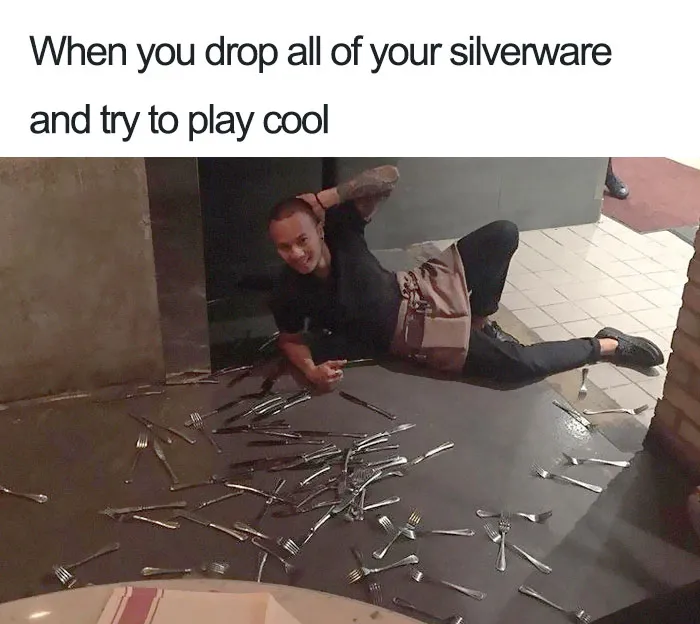 Restaurant worker humorously posing next to silverware spilled on the floor.