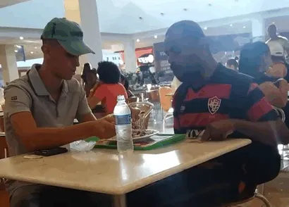 Empleado de un restaurante de comida rápida ayudando a un cliente discapacitado