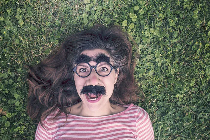 Photo of woman with black fake eyebrows and moustache