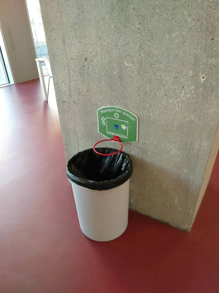 Para evitar que la gente ensucie, ponen canastas sobre las papeleras de este colegio