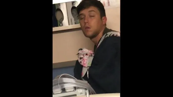 Sleepy Dad Assumes Rolled-Up Blanket In His Arms Is His Newborn Baby