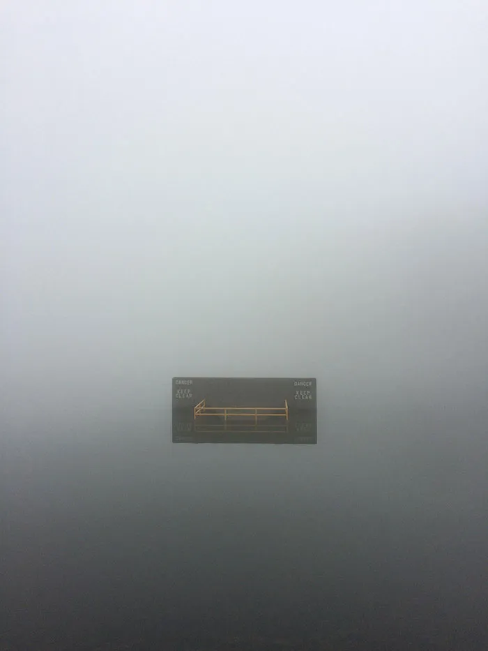 La niebla sobre el lago hace que el cartel parezca estar rodeado de nada