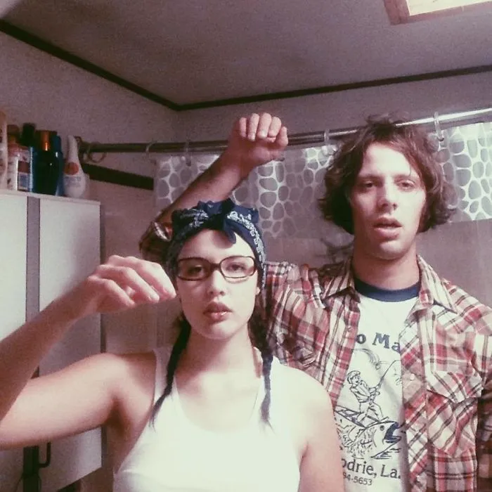 A couple posing in casual retro outfits, easy couples Halloween costume ideas.
