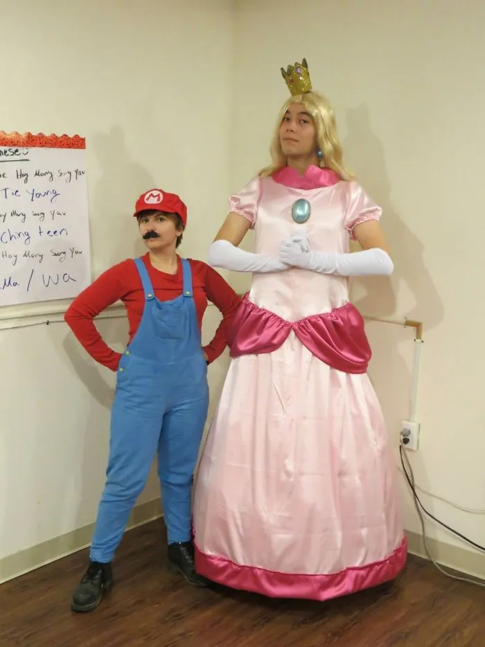 Couple dressed in Mario and Princess Peach costumes for Halloween.