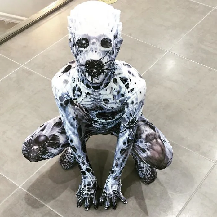 Person crouching in a creepy spider web bodysuit, featuring scary Halloween costume ideas.
