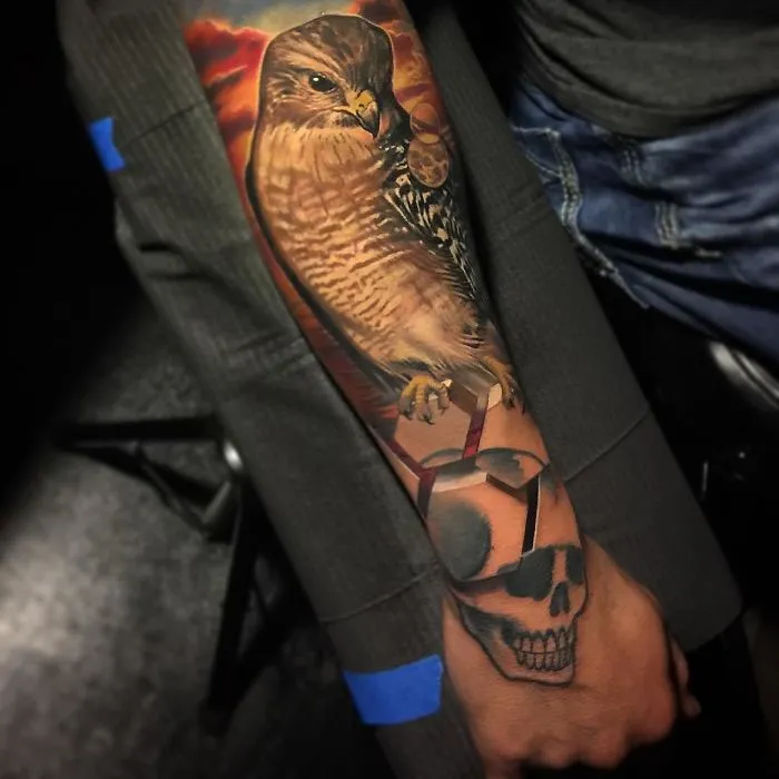 3D tattoo of a hawk and skull on arm, showcasing amazing artistic detail and realism.