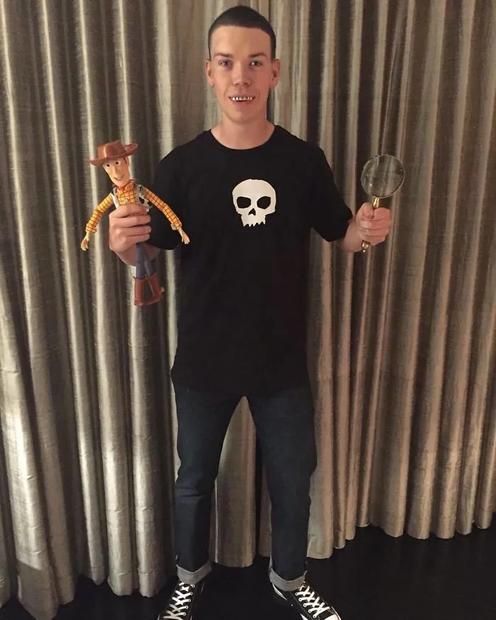A man dressed as Sid from Toy Story for a Halloween costume idea holding a Woody doll and magnifying glass.