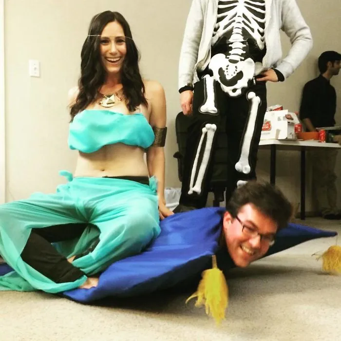 A woman as Jasmine and a man as the magic carpet posing for a humorous couples Halloween costume idea.