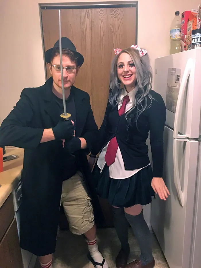 Fun couples Halloween costume ideas showing a man in a trenchcoat with a sword next to a girl in a school uniform