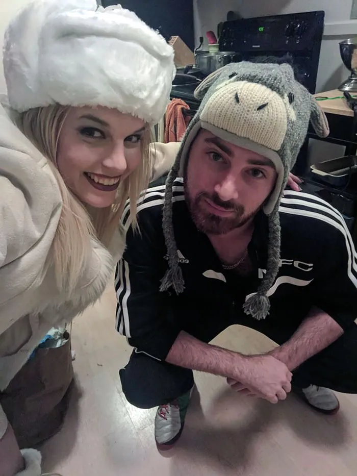 A couple taking a selfie in winter hats and tracksuits, showcasing fun couples Halloween costume ideas.