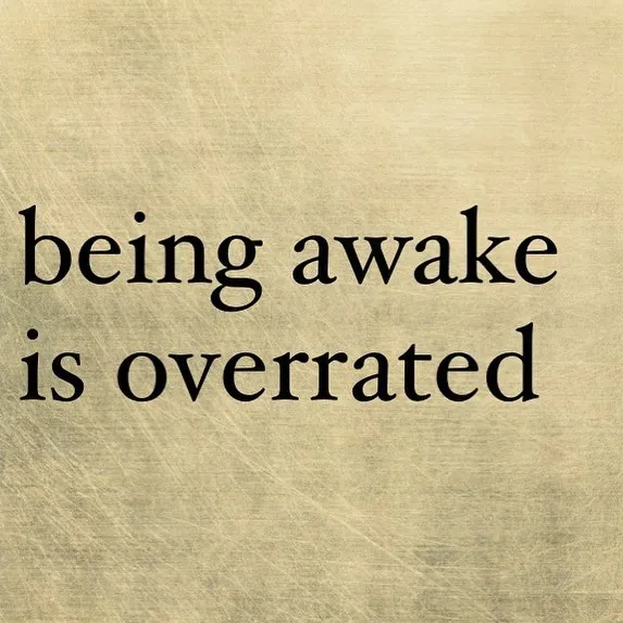 Pessimistic Instagram quote on a textured background stating being awake is overrated.
