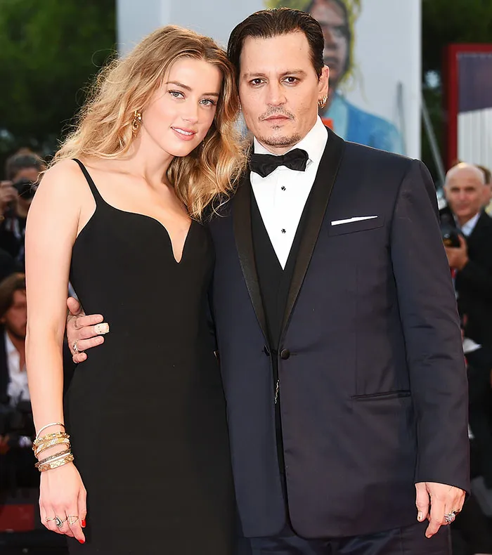 Couple of celebrities posing on the red carpet, highlighting romantic stories of celebrities who fell in love while acting together.